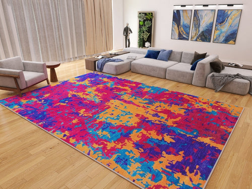 Load image 1 in gallery view. A modern living room with a light wood floor, gray sectional sofa, Celestial Tapestry - Washable Rug - JRS004 in red, orange, pink, and blue—ideal for high-traffic areas—plus wall art, an armchair, and floor-to-ceiling curtains.