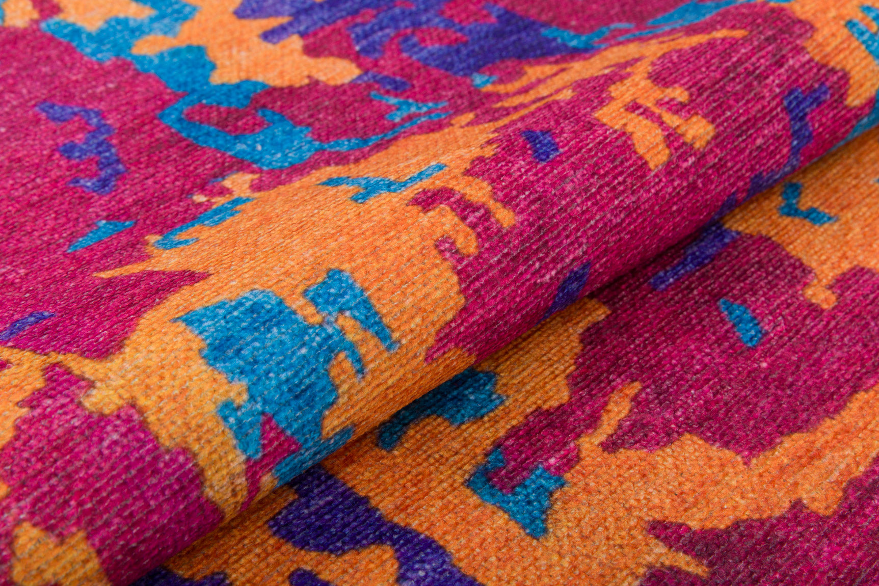 A close-up of the Celestial Tapestry - Washable Rug - JRS004 reveals its vibrant magenta, orange, yellow, blue, and purple abstract patterns with textured folds—perfect for high-traffic areas.