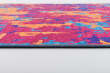 A close-up of the Celestial Tapestry - Washable Rug - JRS004 shows its colorful abstract pattern in pink, orange, blue, and purple on white. The visible edge reveals its thickness—perfect for high-traffic areas.