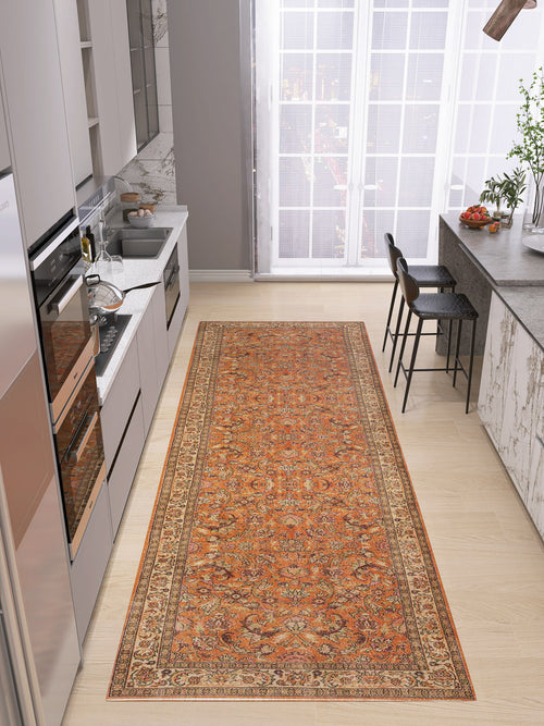 Load image 1 in gallery view. A modern kitchen with light wood floors, gray cabinets, and marble accents features a long Celestial Vintage - Washable Rug - JRN1020 in orange. Bar stools line the gray island near large windows draped with sheer curtains.