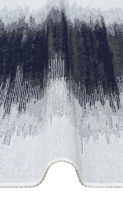 Load image 1 in gallery view. A close-up of the Charcoal Frame - Washable Double-Sided Kilims - AR40, a black and white rug with wavy edges, showcasing an abstract pattern in dark blue, gray, and white with vertical textured lines.