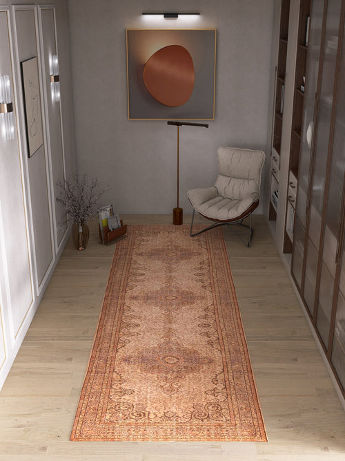Load image 1 in gallery view. A modern hallway with the Chateau Elegance - Washable Rug - JRN1018 in orange, a white cushioned chair, tall floor lamp, round minimalist wall art, right-side shelving, and a vase of branches on the left.