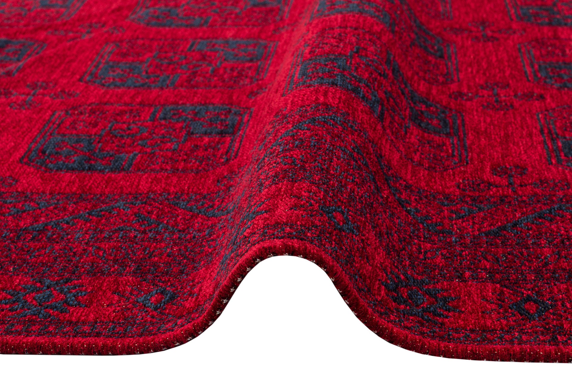 A close-up of the Cherry Texture - Kilim - BHR01, a cherry red machine-made rug with wave-like folds, features intricate geometric Turkish patterns on a white background.