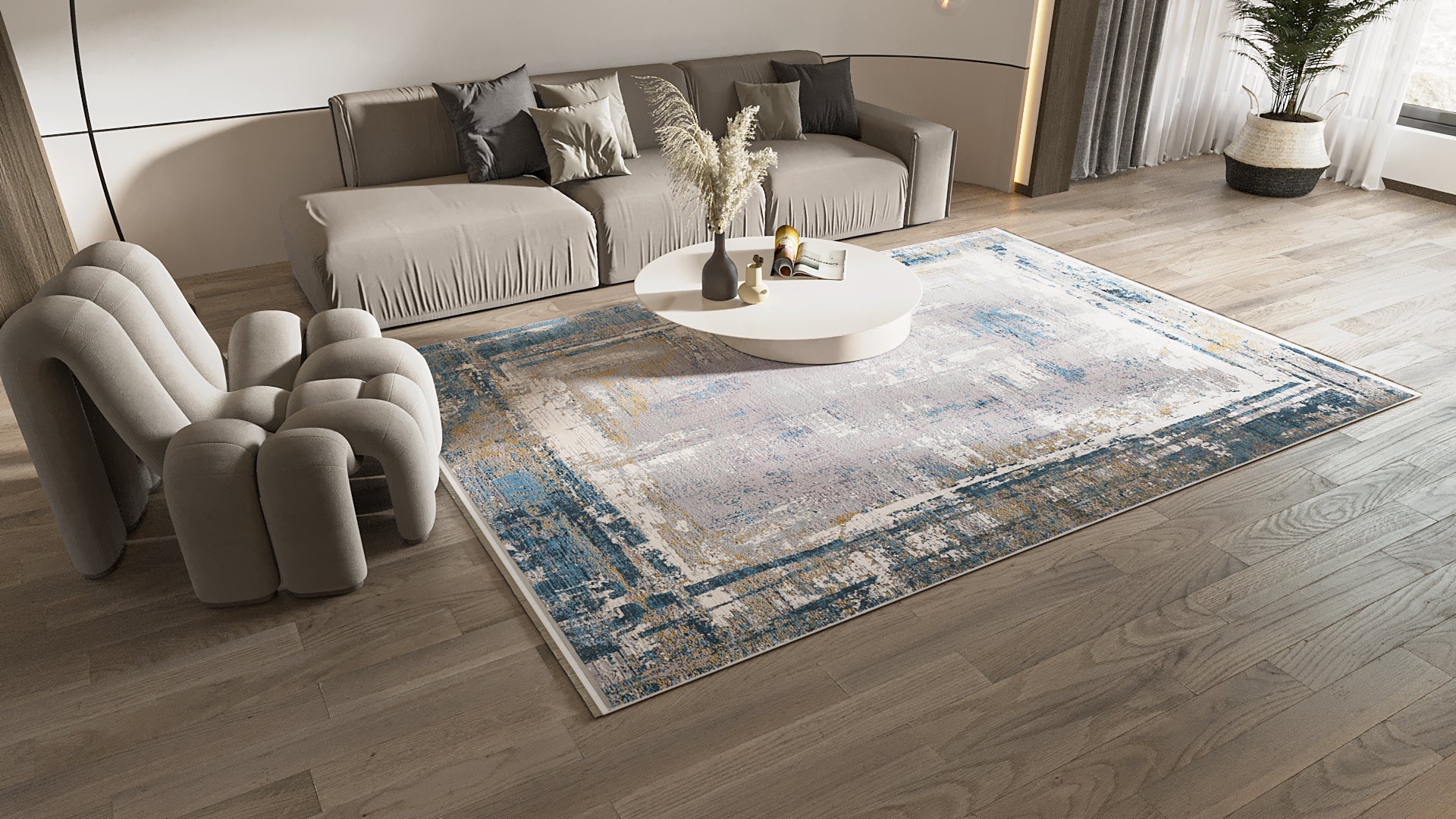 A modern living room features a gray sofa, sculptural beige chair, round white coffee table with decor, wood flooring, natural light from large windows with neutral curtains, and a ChromaBurst Premium Rug - Blue - MT176.