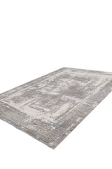 The ChromaBurst Premium Rug - Bright - MT177 features a rectangular shape with a distressed, abstract pattern in gray, beige, and cream, shown from a low-angle perspective.