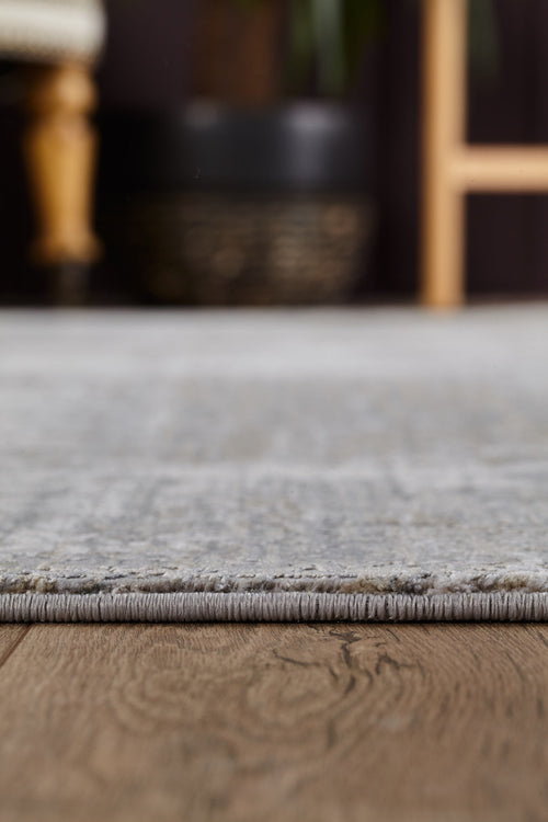 Load image 1 in gallery view. Close-up of the ChromaBurst Premium Rug - Bright - MT177 on a wooden floor, with blurred furniture and a plant pot in the background.