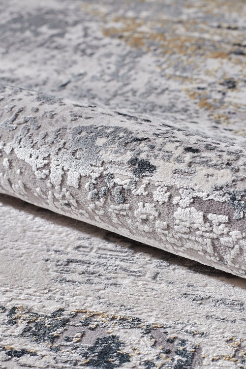 Load image 1 in gallery view. A close-up of the ChromaBurst Premium Rug - Dark - MT175 shows its textured, machine-made surface with light gray, beige, dark blue, and gold in an abstract pattern for a stylish yet durable finish.