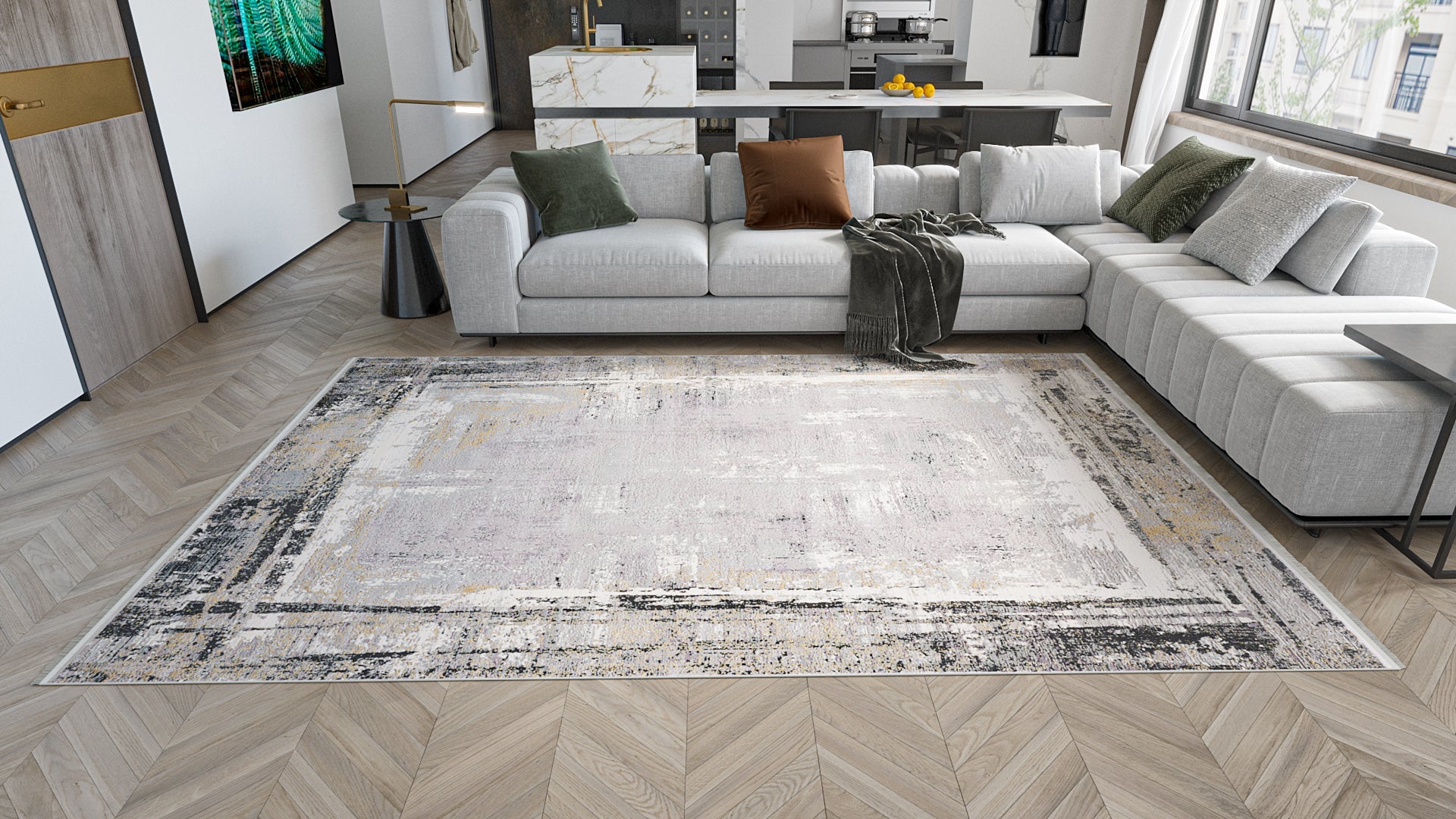 A modern living room with a light gray sectional sofa, assorted throw pillows, a dark throw blanket, wood herringbone flooring, an open kitchen in the background, and a large ChromaBurst Premium Rug - Dark - MT175.