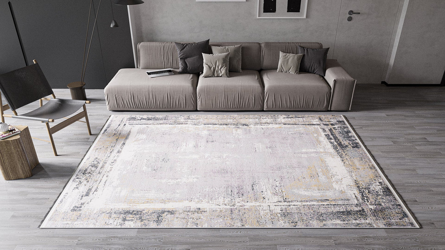 A modern living room featuring the ChromaBurst Premium Rug - Dark - MT175 on a gray wooden floor, with a taupe sofa, gray and beige pillows, a black chair, a round side table, and minimalist neutral-toned decor.