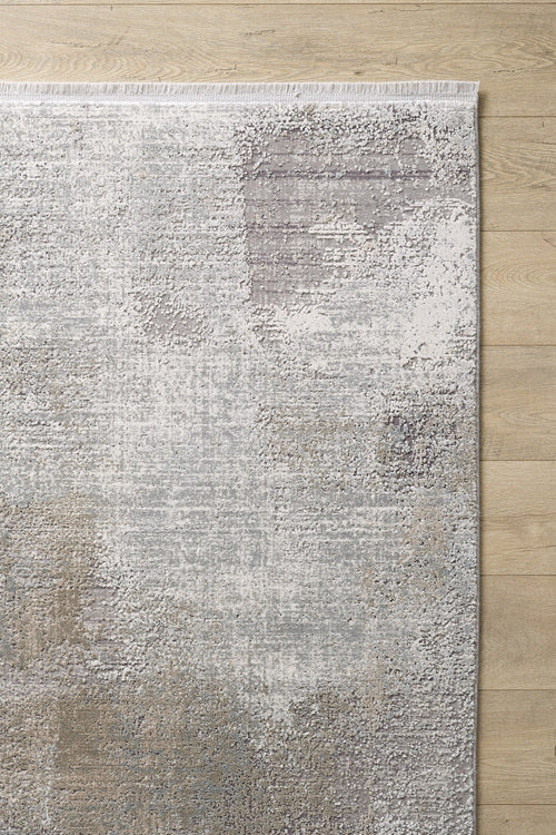 Load image 1 in gallery view. The Chromatic Flair Contemporary Rug - Latte - M660D, with its mottled gray, beige, and ivory pattern and fringed edge, brings abstract style and texture to any space atop a light wood floor.