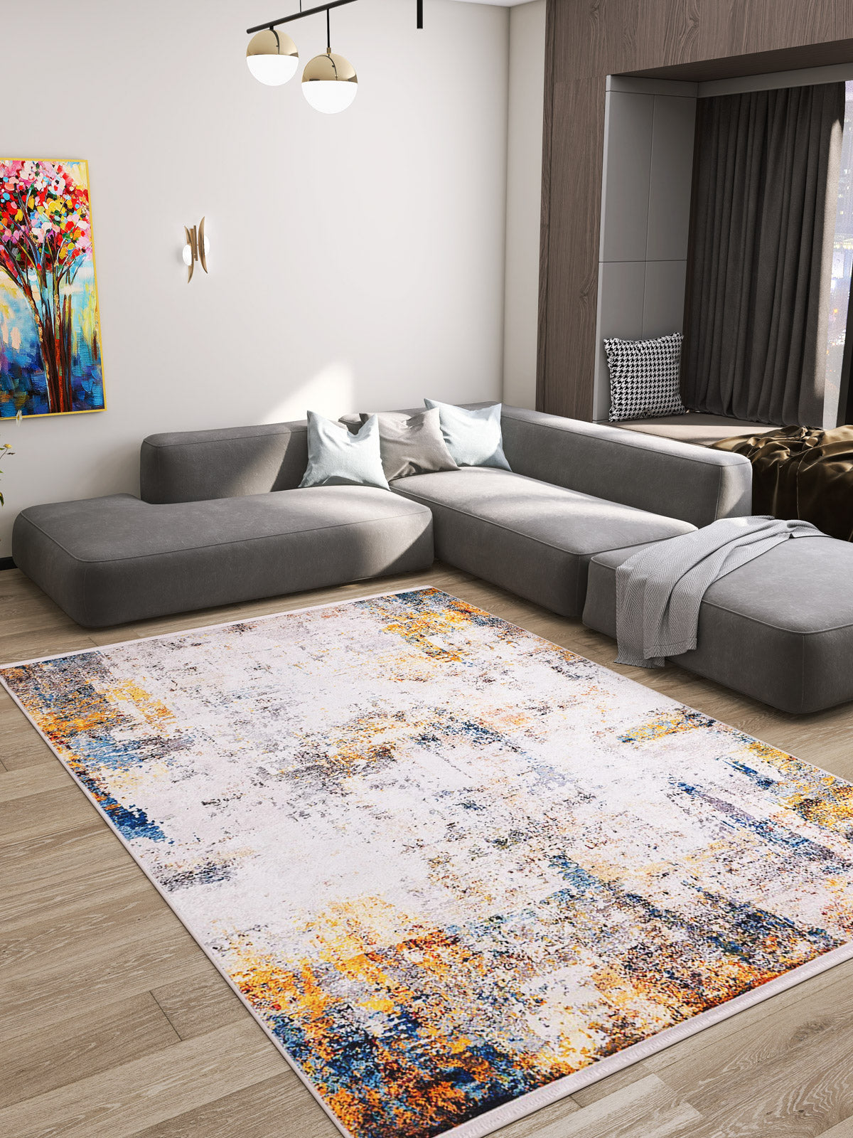 Modern living room with a large gray sectional, a colorful abstract painting, and the Chromatic Kaleidoscope - Washable Rug - JR1483, ideal for high-traffic areas. A cozy window nook features soft cushions and a throw blanket for relaxing moments.