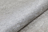 A close-up of the Cinnamon Swirl - Washable Rug - JR425 (Custom Size), showing its light gray, textured surface with a subtle metallic sheen—perfect for flat weaves or coordinating with cream and beige rugs.