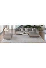 A modern living room features a gray sectional sofa, matching ottoman, white coffee tables, lamp, decorative plants near large windows with white curtains, and the Classic Contrast - Washable Rug - JR1985 (Custom Size) as a stylish flat weave rug.
