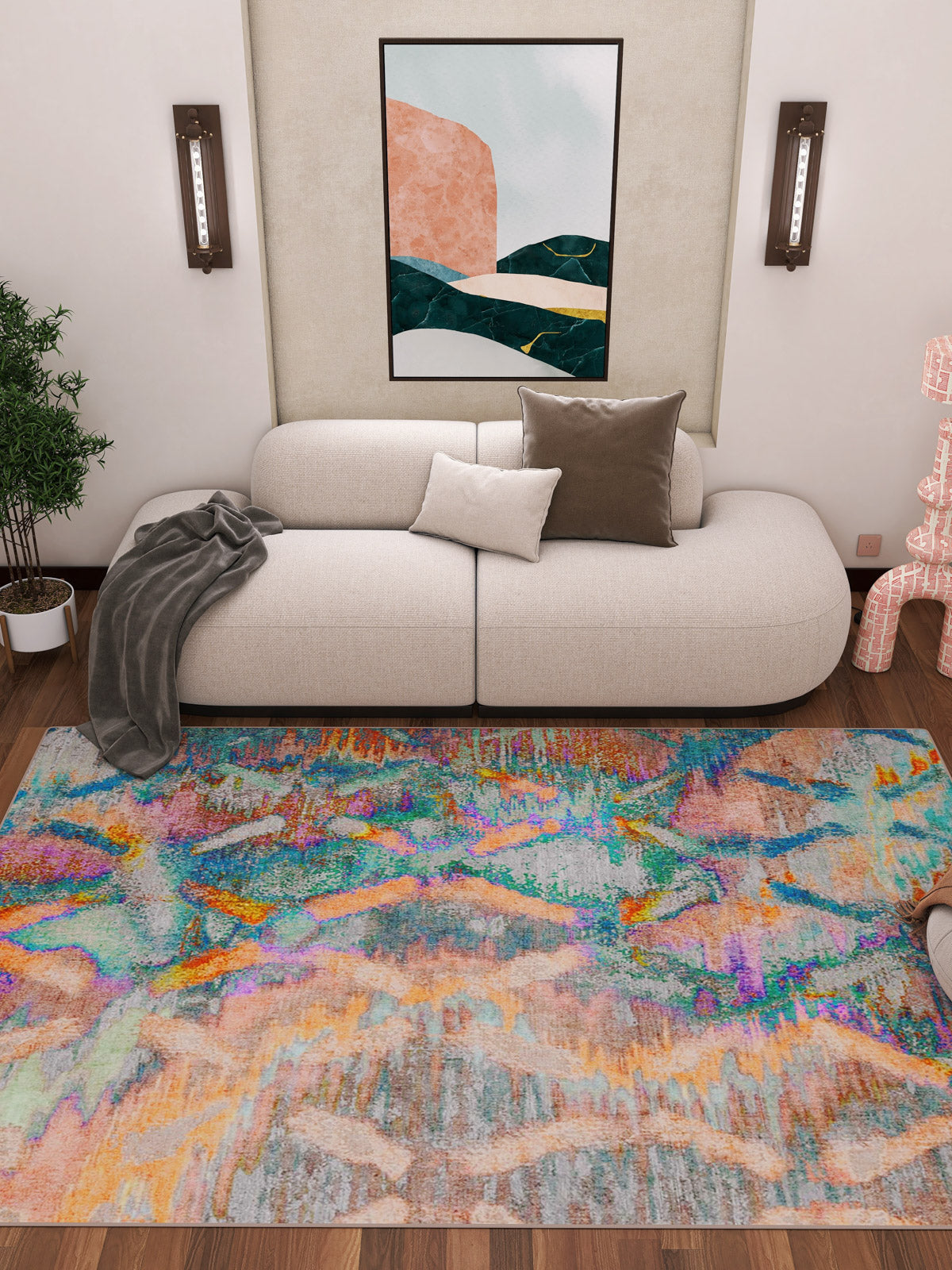A modern living room with a curved white sofa, neutral cushions, gray throw, and the Classic Motif - Washable Rug - JRN29 featuring colorful geometric patterns—ideal for high-traffic areas. Green plant, wall sconces, and abstract art complete the space.