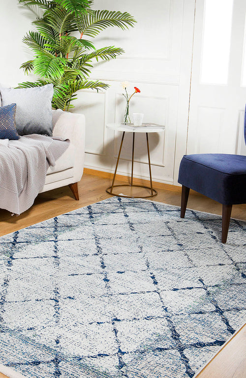 Load image 1 in gallery view. A cozy living room features a white sofa, blue chair, side table with a flower vase, potted plant, and the Classic Trellis - Washable Rug - JR710 on wooden floors. Natural light highlights the rug's stylish and allergy-friendly design.