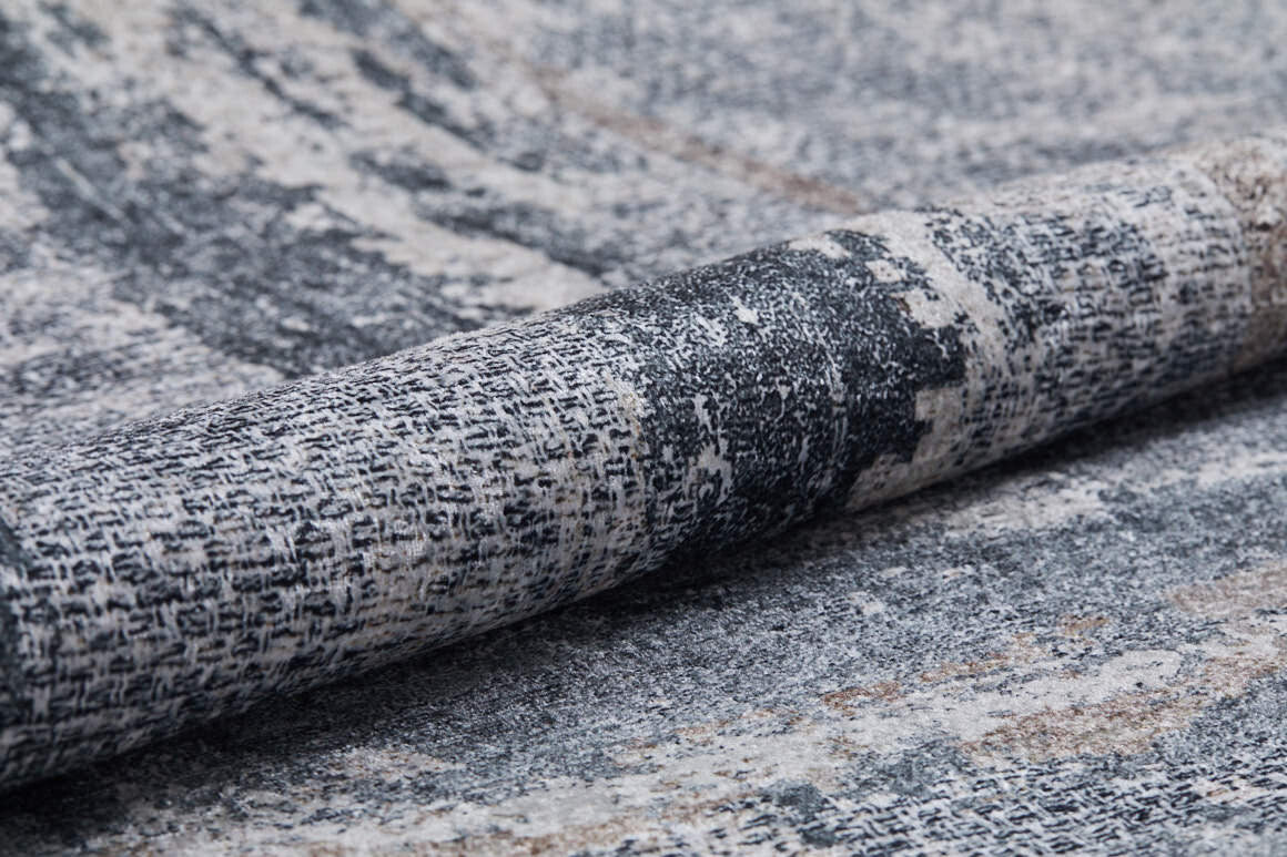 A close-up of the Classic and Bold - Washable Rug - JR1529 (Custom Size), featuring a durable gray and beige woven fabric with a distressed, patterned design that highlights its textured, washable surface.