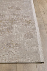 The Cloudscape Geometry Modern Rug - M533B, in beige and light brown with subtle geometric and abstract details and fringed edges on one side, is displayed on a wooden floor.
