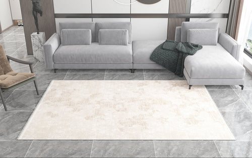 Load image 1 in gallery view. A modern living room with a gray sectional, green textured blanket, beige accent chair, and gray marble tile flooring. The Cloudscape Geometry Modern Rug - M533B adds a light geometric touch to this bright, minimalist neutral space.