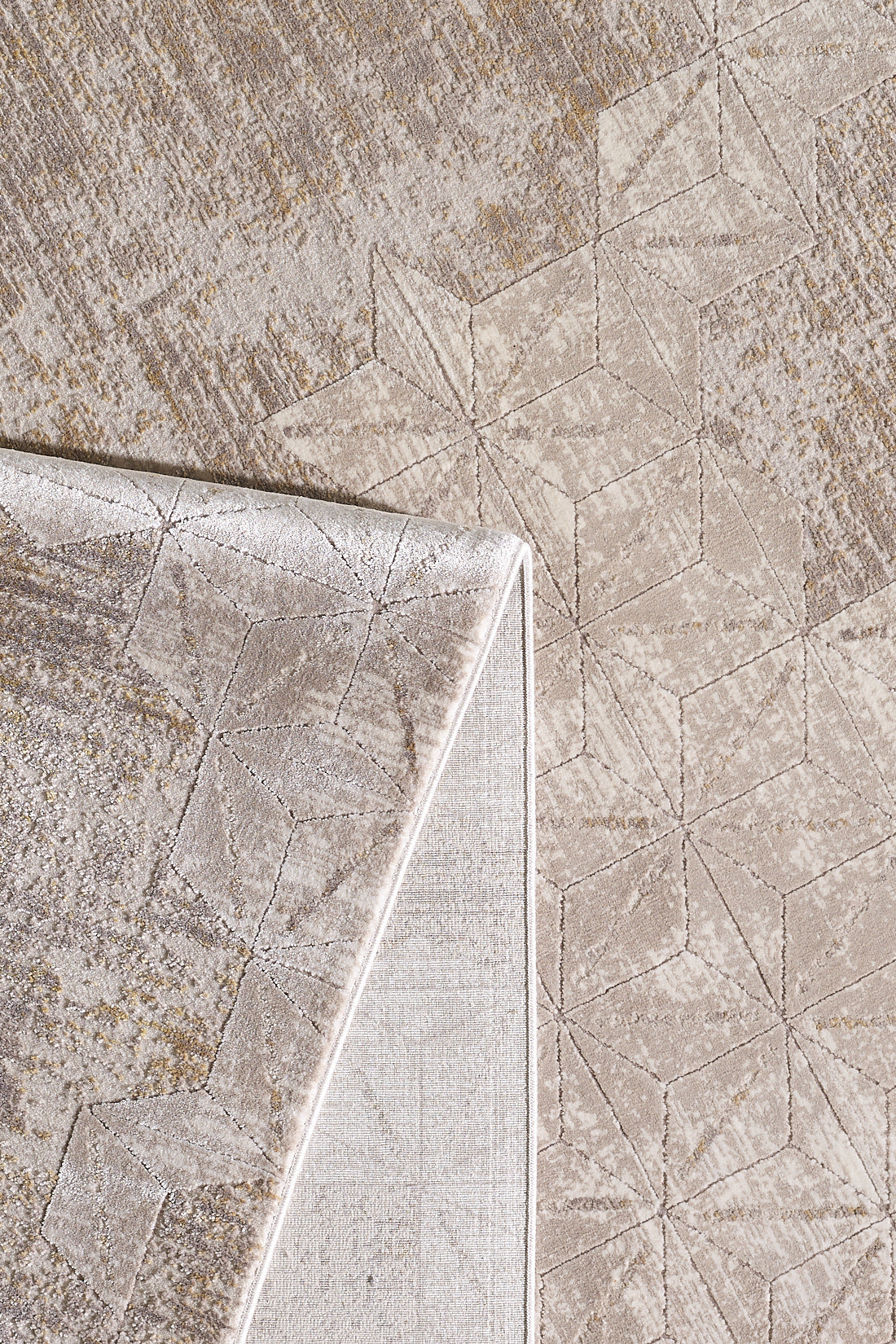 A close-up of the Cloudscape Geometry Modern Rug - M533B, featuring a beige geometric pattern and modern design. One corner is flipped to show the underside and display the machine-made texture and subtle color variations on both sides.