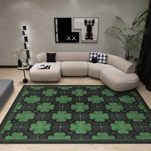 Load image 1 in gallery view. Modern living room with a light beige sectional, black-and-white cushion, Clover Noir - Washable Rug - JRS012 in green and black cloverleaf, black wall art, and a potted plant in the corner.