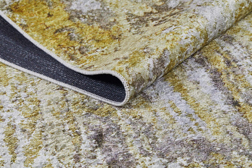 Load image 1 in gallery view. A close-up of the Color Splash - Washable Rug - JR146 (Custom Size) shows its yellow-gold, gray, and white abstract pattern with one corner folded to reveal the dark gray underside—ideal for high-traffic areas.