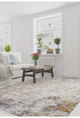 A bright living room features a white sofa, patterned pillows, and a rustic coffee table atop the Contemporary Canvas - Washable Rug - JR145—perfect for high-traffic spaces. Books, flowers, and plants add charm as sunlight pours through large windows.