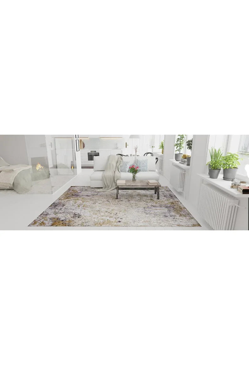 A bright, modern living room with white walls and furniture features the Contemporary Canvas - Washable Rug - JR145 in yellow-gold, perfect for high-traffic areas, plus a coffee table with flowers, potted plants on the windowsill, and a cozy fireplace.