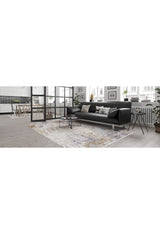 A modern living room with a black sofa, cushions, and the Contemporary Canvas - Washable Rug - JR145 (Custom Size). Large windows brighten the space, with a small coffee table and nearby dining area—ideal for high-traffic areas.