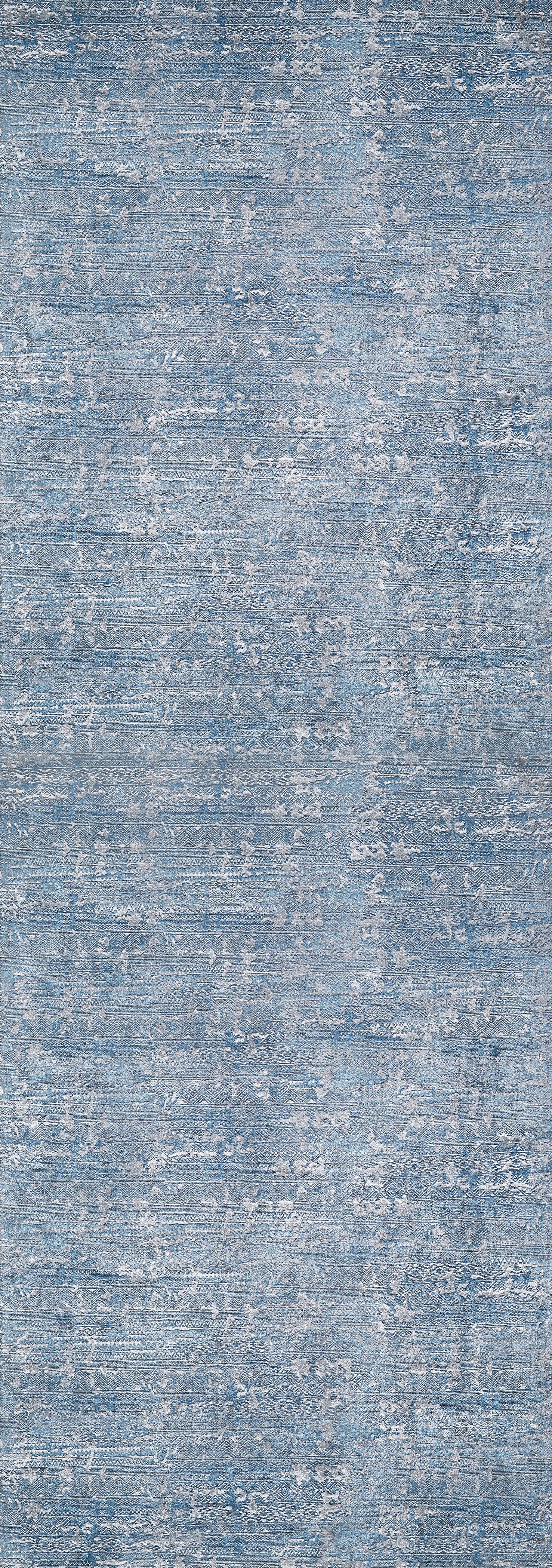 The Contemporary Serenity - Machine-Washable Rug JR1884 features a blue and gray mottled design with a textured, fabric-like look. Its soft surface and washable material make it ideal for high-traffic spaces, blending style with practical durability.