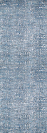 The Contemporary Serenity - Machine-Washable Rug JR1884 features a blue and gray mottled design with a textured, fabric-like look. Its soft surface and washable material make it ideal for high-traffic spaces, blending style with practical durability.