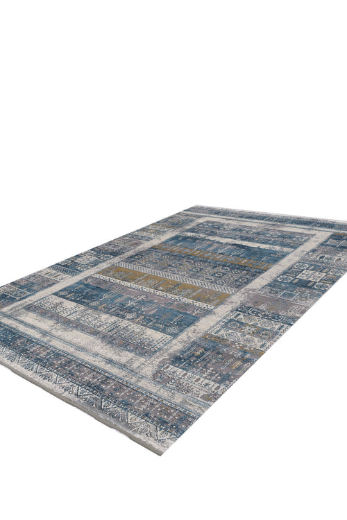Load image 1 in gallery view. The Cool Nomadica Premium Rug - M366B is a rectangular, machine-made piece with a distressed patchwork design in blue, gray, and beige, featuring tribal geometric patterns and a bold border, shown on a white background.