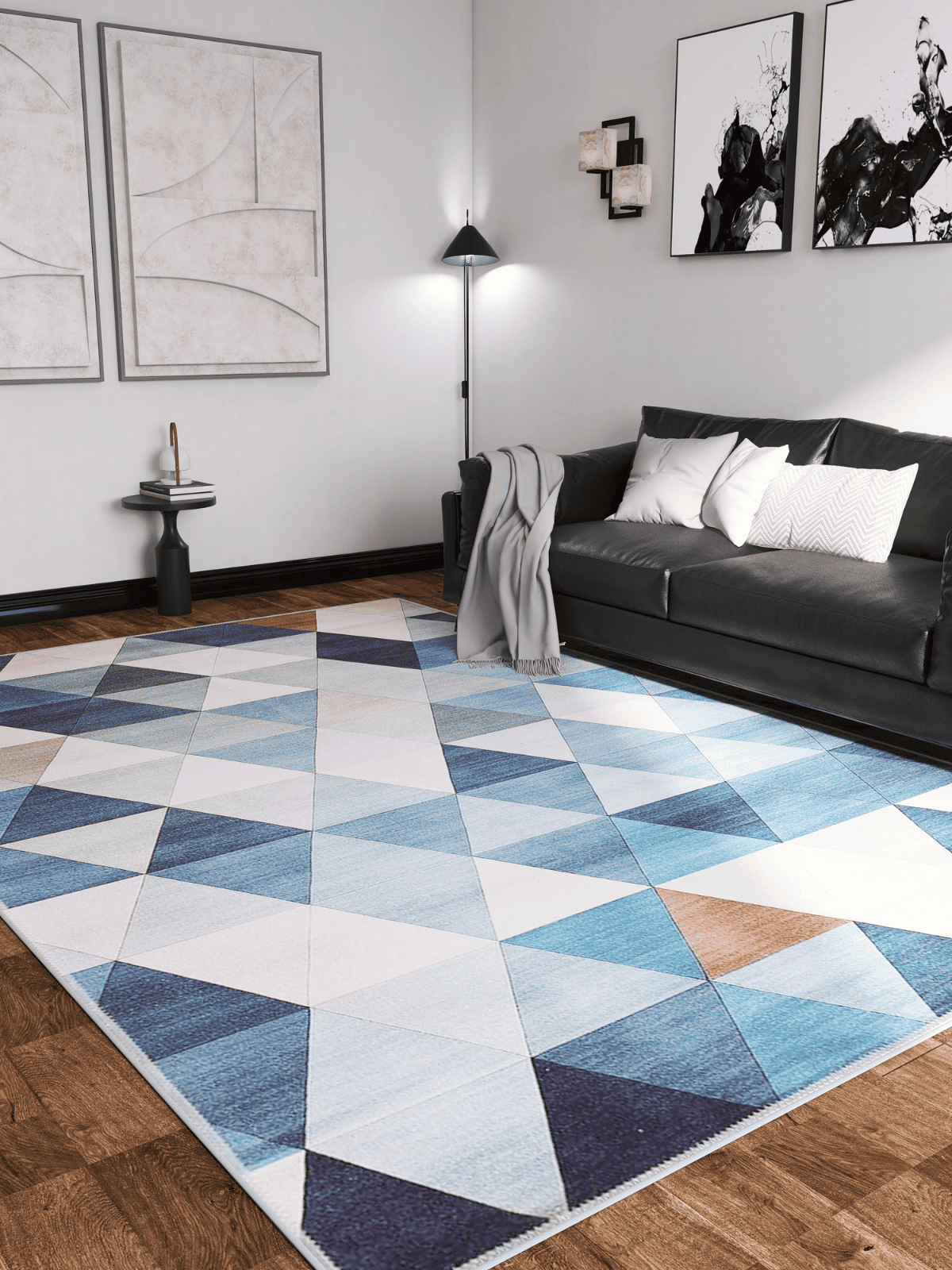 A modern living room featuring the Cubism Collage Blue Washable Rug - MDJ008, ideal for high-traffic areas, paired with a dark gray sofa, white and gray pillows, a gray throw blanket, abstract wall art, side table, and floor lamp.