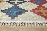 A close-up of the Desert Mirage - Washable Rug - JR5033 (Custom Size), showcasing geometric patterns in blue, black, red, and orange on a light background with a white fringe—ideal for high-traffic areas on wooden floors.