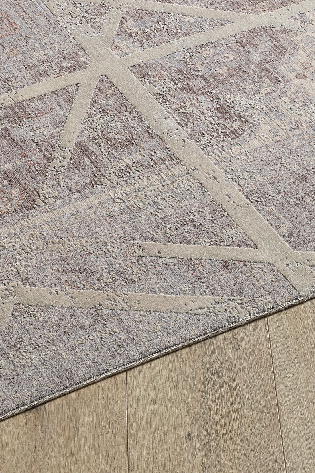 A corner of the Dominant Lineage Modern Rug - Bright - M633M features intersecting cream lines on a mottled gray and beige background, displayed on a light wood floor.