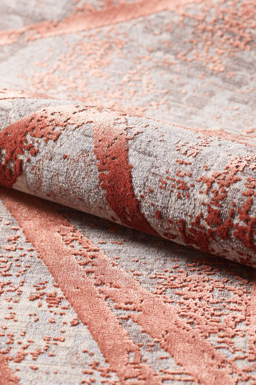 Load image 1 in gallery view. A close-up of the Dominant Lineage Modern Rug - Coral (HRD003), showing its plush, machine-made texture and raised abstract rust and blush pattern on a light gray background. The fabric is slightly rolled to highlight its softness.