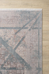 A close-up of the Dominant Lineage Modern Rug - Grey (HRD006), featuring an abstract geometric X pattern in muted gray and beige tones with top-edge fringe, displayed on a light wood floor.