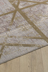 A close-up of the Dominant Lineage Modern Rug - Harvest - M633N shows intersecting gold lines on a textured, muted background, partially on a wooden floor.