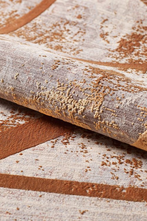 Load image 1 in gallery view. A close-up of the Dominant Lineage Modern Rug - Tangerine (HRD007) highlighting its machine-made abstract pattern in brown, beige, and gold tones with a textured, raised design.