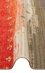 A close-up of the Dust Trace - Kilim - NMD12 shows a wavy fold, highlighting its gradient red, beige, and blue tones with subtle geometric and dotted patterns woven into the modern rug.