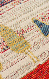 Close-up of Dust Trace - Kilim - NMD12 fabric, showcasing abstract geometric patterns in yellow, blue, red, and cream with textured woven details and repeating horizontal shapes inspired by modern kilim rugs.