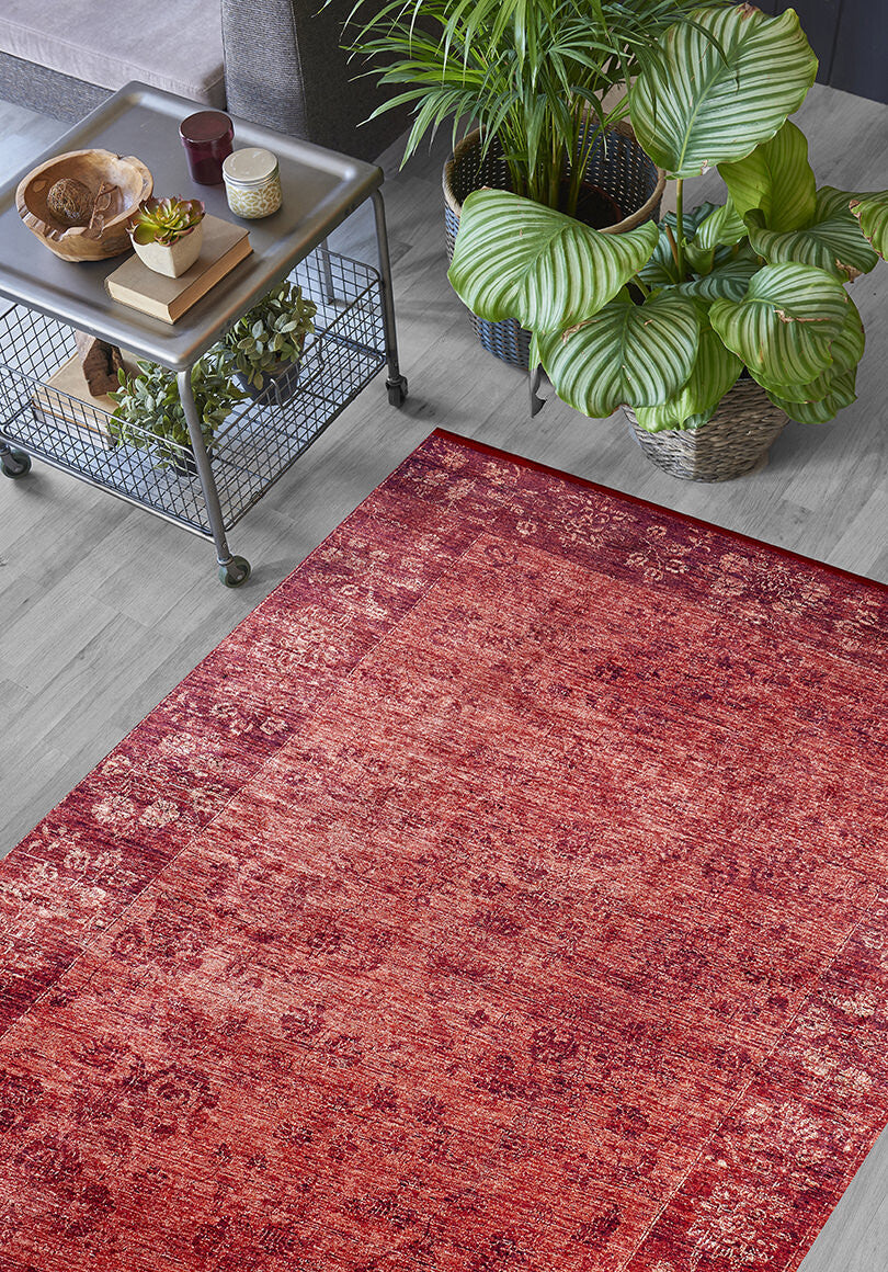 The Dynasty Dream - Washable Rug - JR160 (Custom Size) with an oriental pattern rests on a light gray wooden floor next to a metal decor cart, large green potted plants, and a dark sofa.