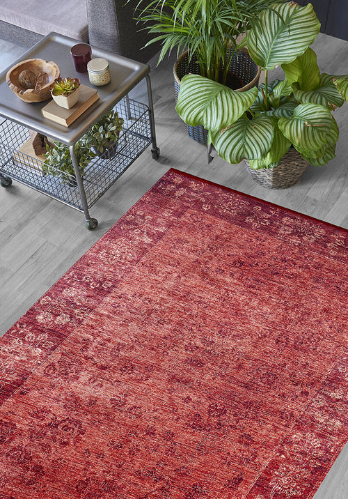 Load image 1 in gallery view. The Dynasty Dream - Washable Rug - JR160 (Custom Size) with an oriental pattern rests on a light gray wooden floor next to a metal decor cart, large green potted plants, and a dark sofa.