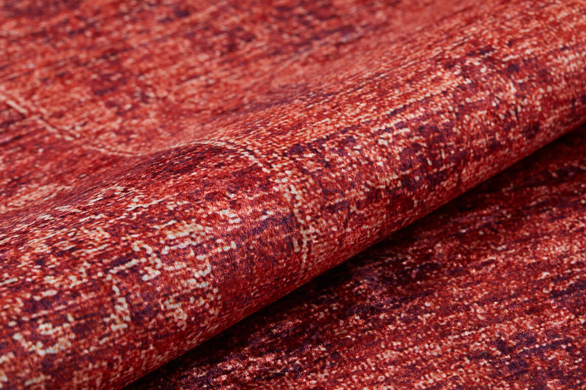 A close-up of the Dynasty Dream - Washable Rug - JR160 (Custom Size) shows its red textured fabric with a mottled, distressed pattern, visible folds, and subtle color variations.