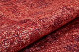 A close-up of the Dynasty Dream - Washable Rug - JR160 (Custom Size) shows its red textured fabric with a mottled, distressed pattern, visible folds, and subtle color variations.