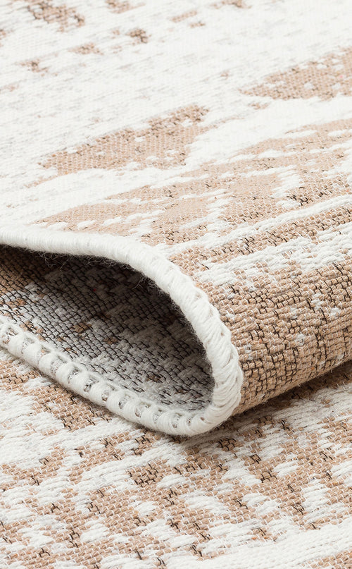 Load image 1 in gallery view. A close-up of the Earth Lines - Washable Double-Sided Kilims - AR06, showing its folded edge, beige and white abstract pattern, and textured, tightly stitched surface.