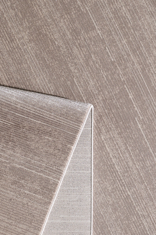 Load image 1 in gallery view. A close-up of the Earthy Textures Neutral Rug - M497J in beige, featuring a subtle linear pattern and one corner folded to display the fabric texture on both sides.