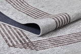 A close-up of the Elegant and Chic - Washable Rug - JR1509 (Custom Size) in gray, featuring dark brown edge stripes; one corner is lifted to show the sturdy underside and stitching, making it ideal for high-traffic areas.