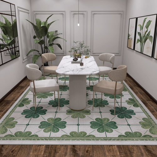 Load image 1 in gallery view. A modern dining room with a marble table, four beige chairs, the Emerald Charm - Washable Rug - JRS013 for high-traffic areas, potted plant, minimal pendant light, and framed art on cream walls over a dark wooden floor.