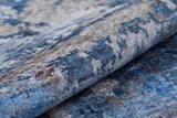 A close-up of the Enigmatic Elegance - Washable Rug - JR787 (Custom Size) showcasing its textured, abstract marbled pattern in blue, gray, and beige—washable and ideal for high-traffic areas.