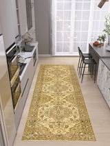A modern kitchen with light gray cabinets, built-in ovens, a long marble countertop, barstools, and a large window features the Eternal Lattice - Washable Rug - JRN1010 in yellow and beige on the light wood floor.
